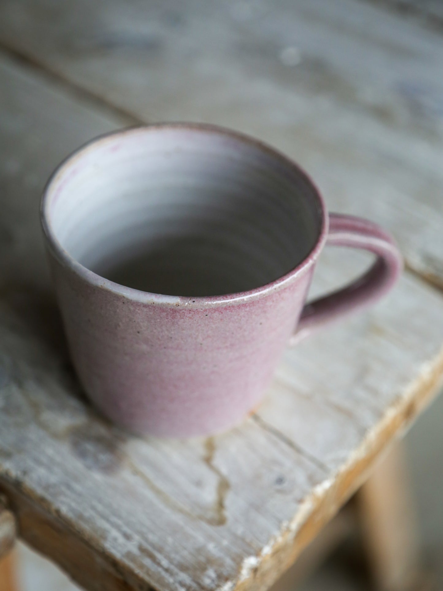 Pink ceramic mug on a wooden surface