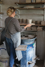 Load image into Gallery viewer, laura lane ceramics in her pottery studio, hold thrown pots
