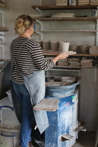 laura lane ceramics in her pottery studio, hold thrown pots
